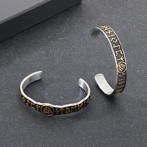 Macro detail of Viking cuff bracelet featuring golden runes and Valknut symbol