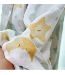 Close-up of soft muslin cotton baby blanket with yellow star and moon print detail
