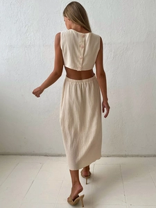Back view of beige two-piece cotton linen set featuring sleeveless crop top and midi skirt