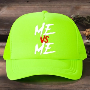 Top view of neon green trucker hat with ME VS ME print on rustic wood background