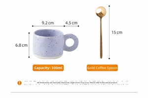 Macro detail of purple ink-splatter ceramic mug with 300ml capacity and golden spoon dimensions