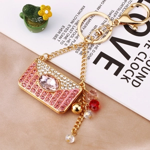 Macro shot of an envelope-shaped keychain with pink rhinestones and a gold metal base