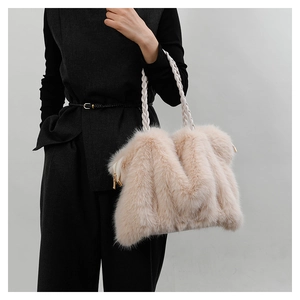 Detail of beige plush tote bag with unique M-shape design and woven top handle