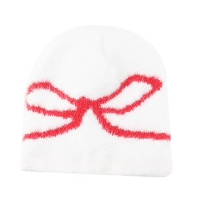 White winter knit beanie with a textured red bow design on a clean white background