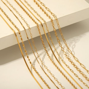 Detail of assorted gold layered chains including snake, bead, and paperclip styles