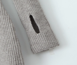 Detail of ribbed knit sleeve featuring a functional thumbhole cuff in oatmeal grey fabric