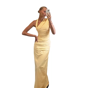Detail of one-shoulder pleated maxi dress in light yellow with slim fit tailoring