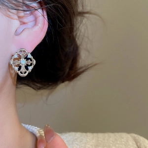 Detail view of silver gothic cross earrings with micro-set zircons on a model
