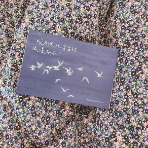Close-up of artistic blue bird postcard on a thick cotton floral tote bag fabric