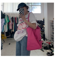 Mirror selfie showing the pink canvas tote bag with side pocket in a studio setting