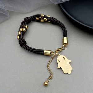 Detail of multi-strand leather bracelet with golden Hamsa Hand pendant and lobster clasp