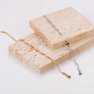 Polished gold and silver pig nose link bracelets on natural stone display boards