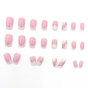 French press-on nails in pink and white with metallic gold stars and line patterns