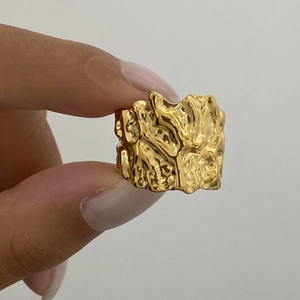 Close-up of golden lava texture open ring featuring an irregular organic design