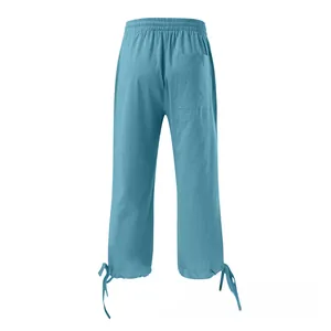 Detail of light blue linen trousers showing elastic waist, back pocket, and drawstring cuffs