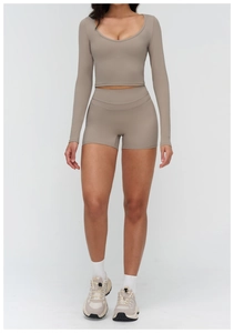 Close-up of taupe long sleeve crop top and high waist yoga shorts set for women