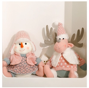 Detail of pink Christmas gnome and reindeer plush with knitted texture in a cozy setting