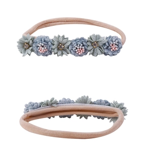 Detailed view of dual handmade fabric flower baby headbands with elastic nylon bands