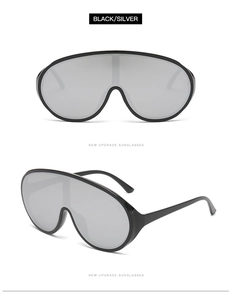 Close-up of black oversized Y2K sunglasses with silver reflective one-piece lenses