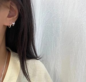 Close-up of 925 sterling silver bow earrings and hoop studs on model's ear