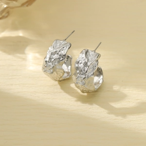Detail of silver pleated leaf earrings in stainless steel with a sparkling zircon stone