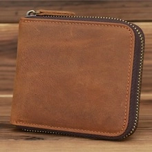 Close-up of vintage brown leather wallet featuring secure zipper closure and rustic texture