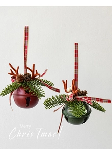 Detail of red and dark green Christmas metal bells with reindeer antlers and pine cones