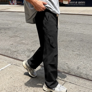 Dettaglio dei pantaloni hip-hop neri a gamba larga con grandi tasche laterali cargo