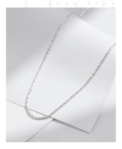 Macro detail of chic faceted s925 silver chain necklace on minimalist white background