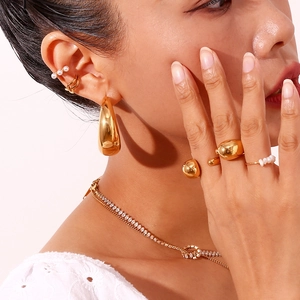 Polished 18K gold plated crescent moon earrings and pearl jewelry set worn by a model