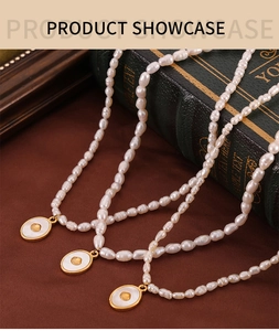 Macro shot of irregular freshwater pearls and gold shell pendant on a vintage book background