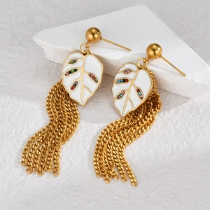 Macro shot of gold leaf earrings with colorful rhinestones and hanging metal fringe
