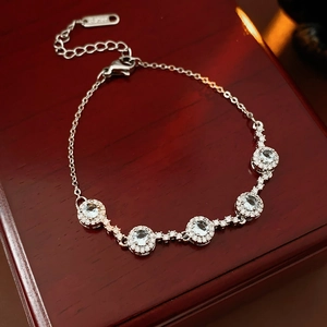 Détail d'un bracelet en argent avec cinq breloques en zircon bleu clair sur un écrin à bijoux