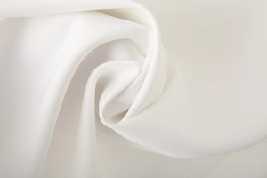 Close-up of high-density white fabric texture with elegant rose-shaped drape detailing