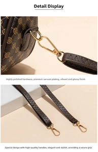 Detail of brown leather saddle bag featuring clover pattern and gold-tone hardware hook