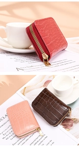 Macro detail of compact crocodile texture card holders with gold zipper in various colors
