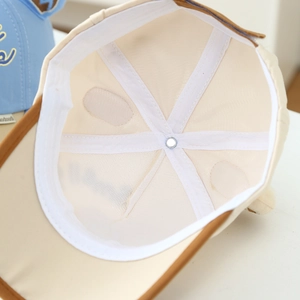 Vue détaillée de la structure interne de la casquette beige avec bandes de renfort blanches