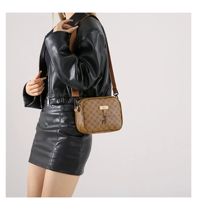 Brown crossbody bag with retro floral pattern and deer pendant on a fashion model