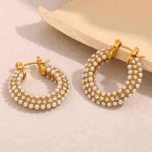 Detailed shot of C-shaped 18K gold plated hoop earrings with micro-set pearls and cubic zirconia