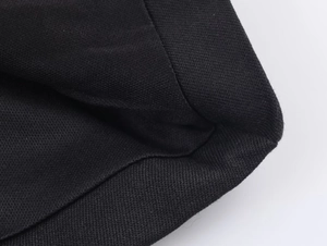 Détail de la texture du tissu noir tissé et des coutures de qualité sur la robe