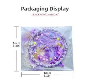 Detail of purple dream catcher with feathers and beads in clear plastic packaging