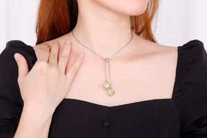 Close-up of Y-shaped silver necklace with sparkling crystal pave ball pendants on a model