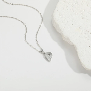 Minimalist silver initial P pendant necklace with honeycomb texture on white rock