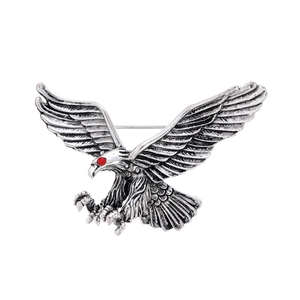 Detail of vintage silver eagle brooch featuring intricate feathers and red rhinestone eyes