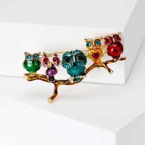 Detail showing five colorful enamel owls on a branch with sparkling rhinestones