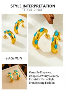 Macro view of C-shaped gold-plated earrings with turquoise stones in a luxury box