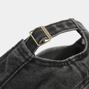 Detail of vintage washed military cap with adjustable antique brass metal buckle strap