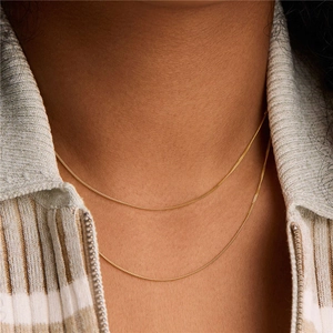 Classic S925 sterling silver thin gold chain necklace shown on a model neck