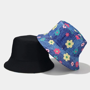 Détail d'un chapeau bob fleuri à côté d'un modèle noir uni montrant le tissu réversible