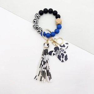 Dettaglio del portachiavi a bracciale western con perline blu e nappa stampa mucca